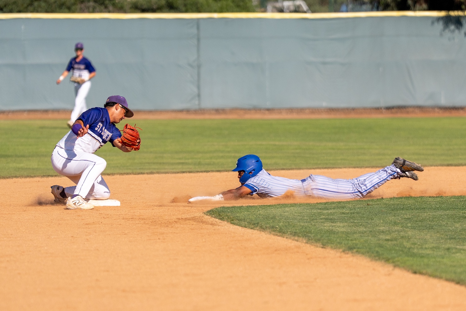 baseball player tagging out the runner at second base