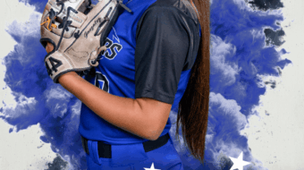 softball player posing for a media day portrait holding her glove up