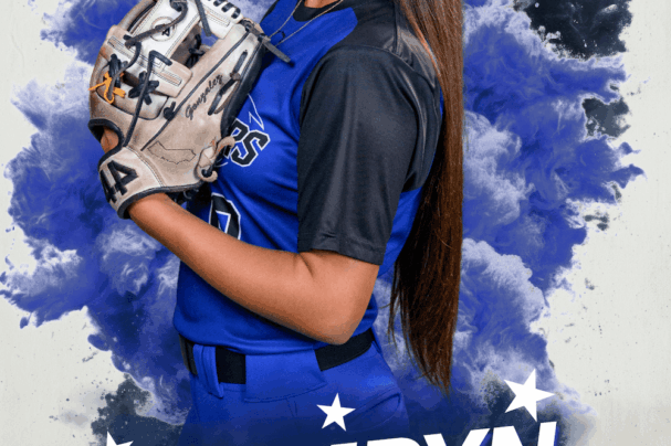 softball player posing for a media day portrait holding her glove up